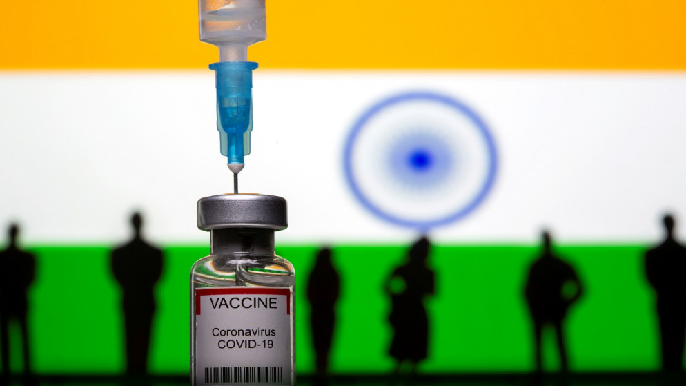 تماثيل صغيرة مطبوعة ثلاثية الأبعاد، حقنة وقارورة تحمل علامة "لقاح فيروس كورونا، أمام علم الهند. 4 مايو 2021. (رويترز)