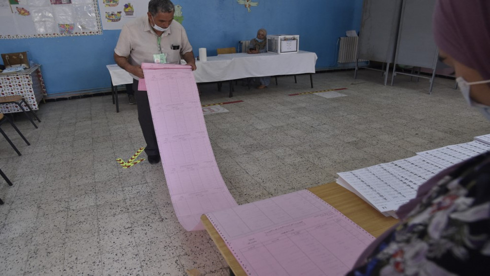 مشرف جزائري على الانتخابات يتفقد قائمة الناخبين خلال الانتخابات البرلمانية في مركز اقتراع في بوشاوي ، في الضواحي الغربية للعاصمة الجزائر ، في 12 يونيو 2021.(أ ف ب)