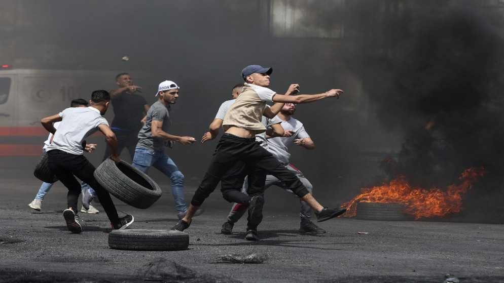 متظاهرون فلسطينيون وسط مواجهات مع قوات الاحتلال الإسرائيلي على حاجز حوارة جنوبي مدينة نابلس بالضفة الغربية المحتلة.21 أيار/مايو 2021.(ا ف ب)