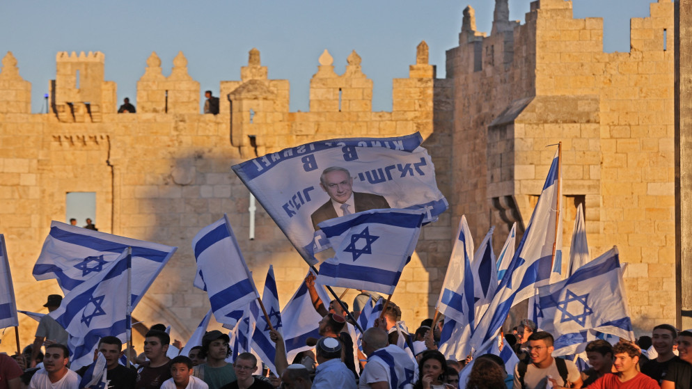رفع أعلام إسرائيلية خلال مسيرة الأعلام المتطرفة خارج باب العامود في البلدة القديمة بالقدس. 15 حزيران/يونيو 2021. (أ ف ب)