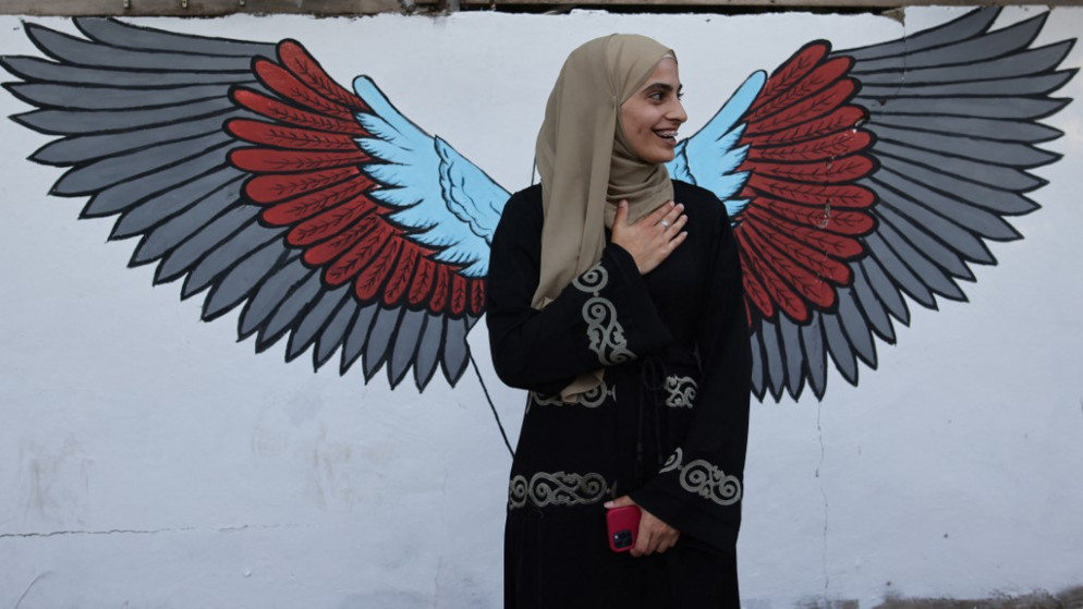 الناشطة المقدسية منى الكرد، عند مدخل حي الشيخ جراح في القدس الشرقية، بعد إطلاق سراحها من مركز تابع للاحتلال الإسرائيلي. 06/06/2021. (أ ف ب)