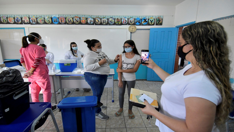 فتاة (12 عاما) تتلقى لقاح واقي من الفيروس في ولاية ميناس جيرايس ، البرازيل ، 16 حزيران/يونيو 2021 (رويترز / واشنطن ألفيس)