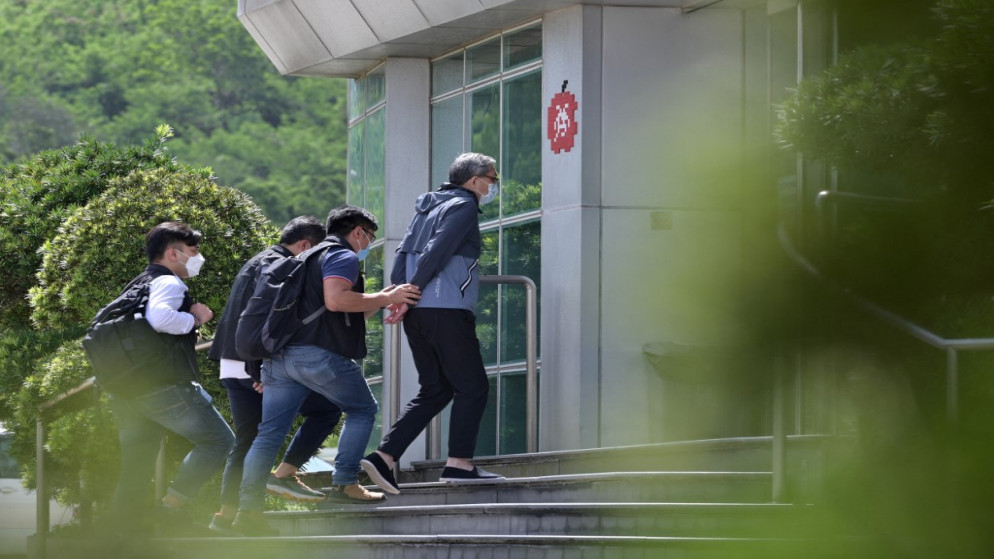 تشيونغ كيم هونغ (وسط) برفقة الشرطة إلى مكاتب صحيفة ديلي آبل في هونغ كونغ، 17 حزيران/يونيو 2021. (أ ف ب)