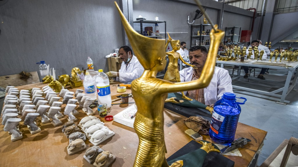 فنانون يرسمون نسخا طبق الأصل من تماثيل للملكة نفرتيتي في مصر القديمة يتم تصنيعها في مصنع تابع للحكومة المصرية. 17/05/2021. (أ ف ب)