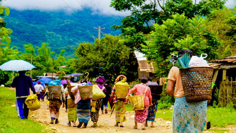 نساء يسرن بعد تلقي تبرعات غذائية في منطقة مونغ باو في ولاية شان حيث احتدم القتال في المنطقة بين الجيش ومختلف الجماعات العرقية المسلحة في شرق بورما، 12 حزيران/يونيو 2021. (أ ف ب)