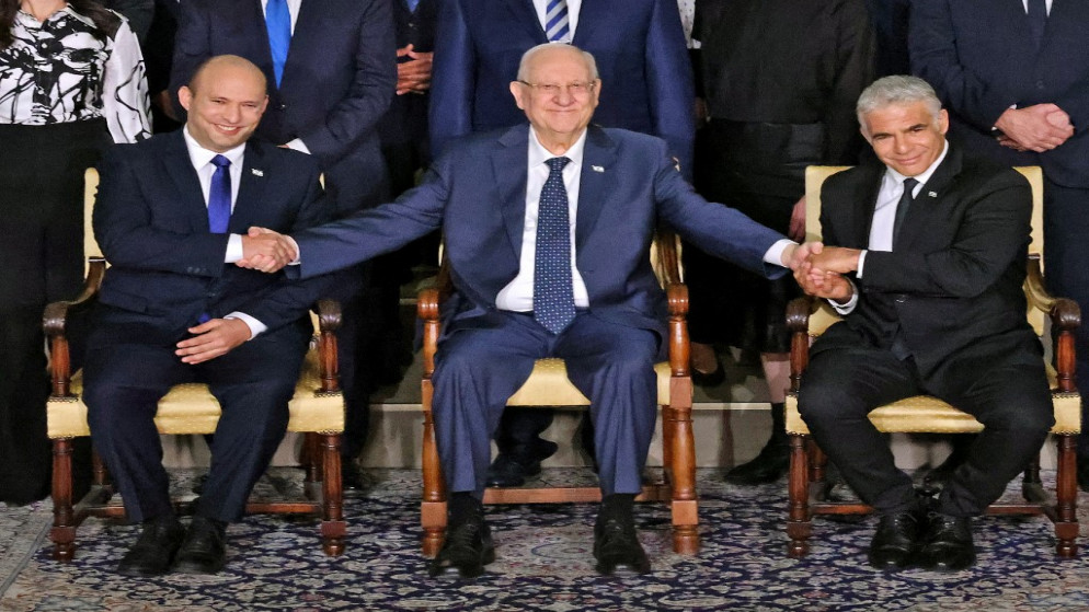 رئيس إسرائيل رؤوفين ريفلين، بين رئيس الوزراء نفتالي بينيت ووزير الخارجية يائير لابيد، القدس المحتلة، 14 حزيران/يونيو 2021. (رويترز)