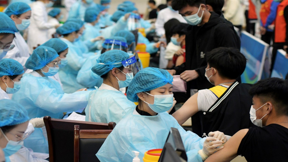 يقوم العاملون في المجال الطبي بتلقيح الطلاب ضد فيروس كورونا، في إحدى الجامعات في تشينغداو، مقاطعة شاندونغ، الصين، 30 آذار/مارس 2021. (رويترز)