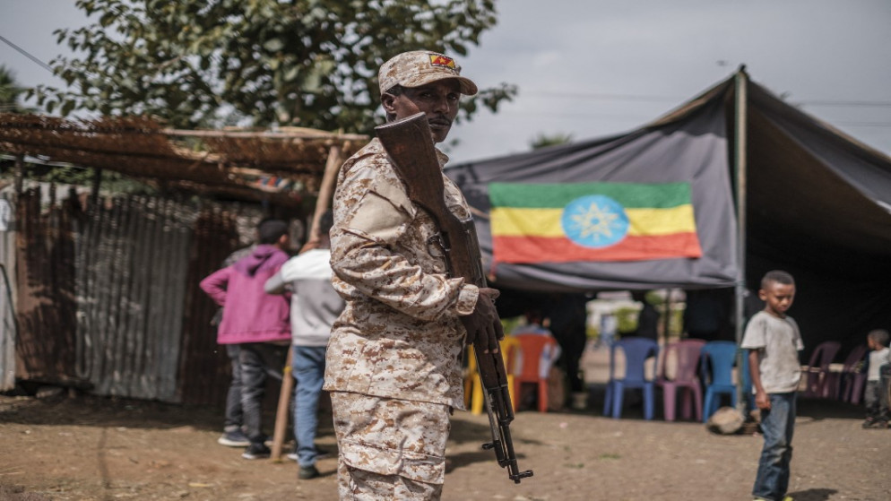 عنصر من قوات الأمهرة الخاصة يحرس مركز اقتراع أثناء توزيع مواد الاقتراع، في مدينة بحر دار، إثيوبيا، 20 حزيران/يونيو 2021. (أ ف ب)