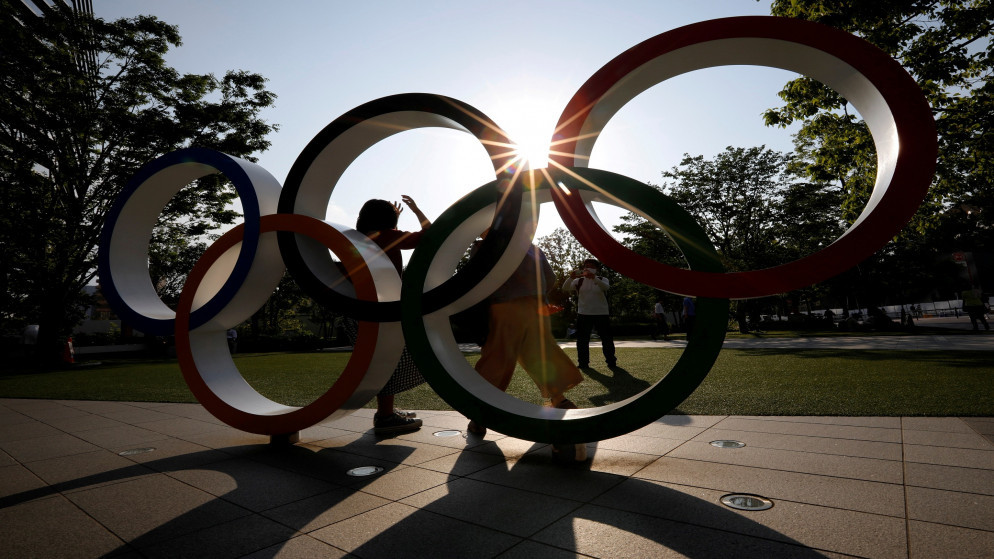يحاول زوار التقاط صور أمام نصب الحلقات الأولمبية خارج مقر اللجنة الأولمبية اليابانية، في طوكيو، اليابان، 30 أيار/مايو 2021. (رويترز)