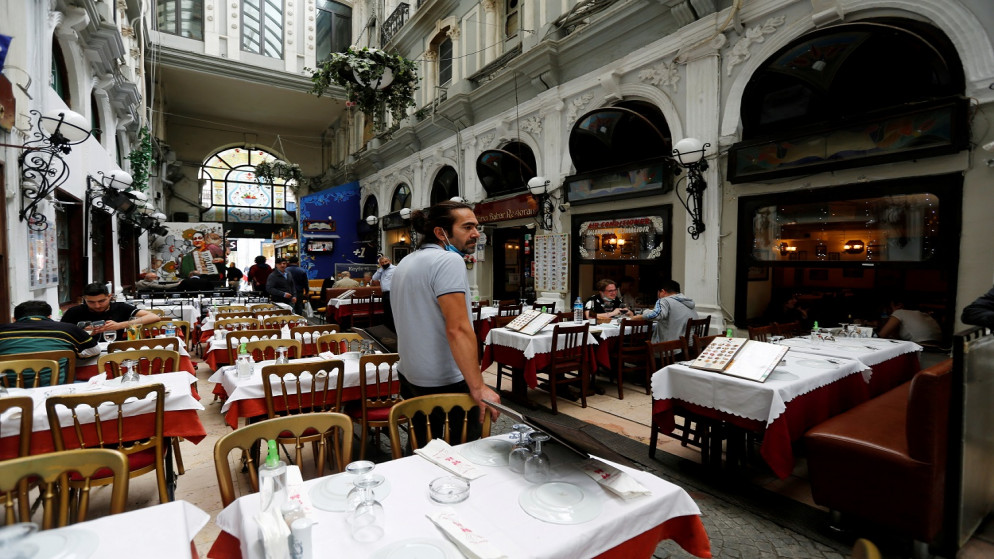 موظف يقف بجانب طاولات فارغة، حيث أعيد فتح المقاهي والمطاعم بعد إغلاقها لعدة أشهر وسط تفشي كورونا، اسطنبول، بتركيا، في الأول من حزيران/يونيو 2021. (رويترز)