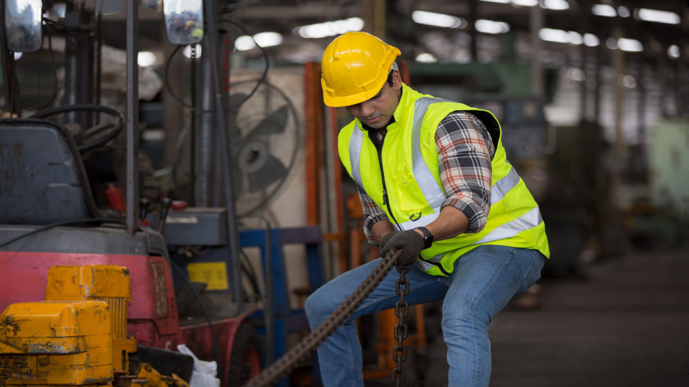 صورة توضيحية لعامل في أحد المصانع يرتدي معدات الحماية. (shutterstock)