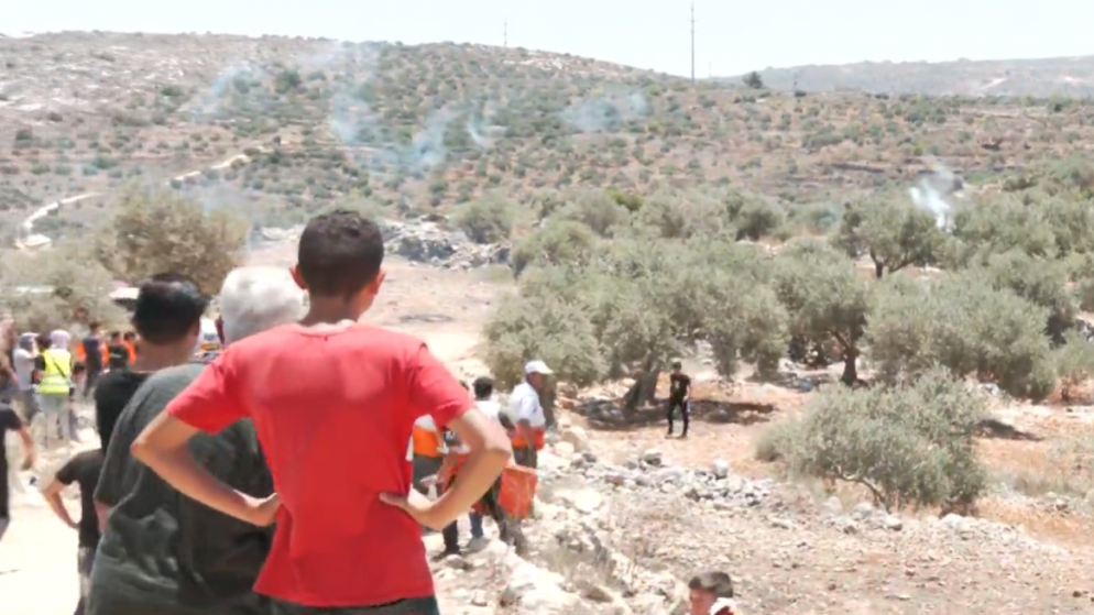 فلسطينيون في قرية بيتا جنوب نابلس وتظهر أعمدة قنابل الغاز التي ألقتها قوات الاحتلال الإسرائيلي.25/6/2021.(المملكة)