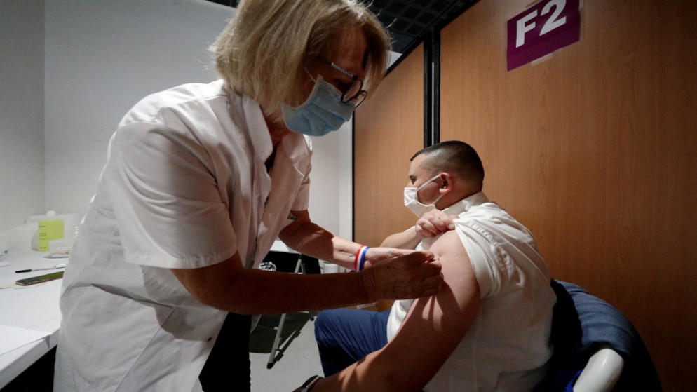 مشجع فرنسي يتلقى جرعة من لقاح مضاد للفيروس، خلال عملية تطعيم في منطقة للمشجعين، خارج باريس، 23 يونيو 2021. (أ ف ب)