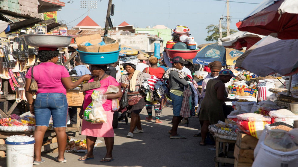 أشخاص يسيرون في سوق بينما يمضون حياتهم في بورت أو برنس، هايتي، 24 مايو 2021. (رويترز)