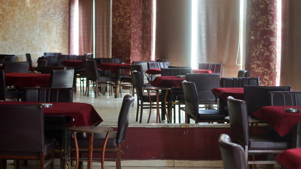 صورة أرشيفية لطاولات فارغة في مقهى مغلق في عمّان؛ بسبب إجراءات الإغلاق لمنع انتشار فيروس كورونا. 18/04/2021. (رويترز)