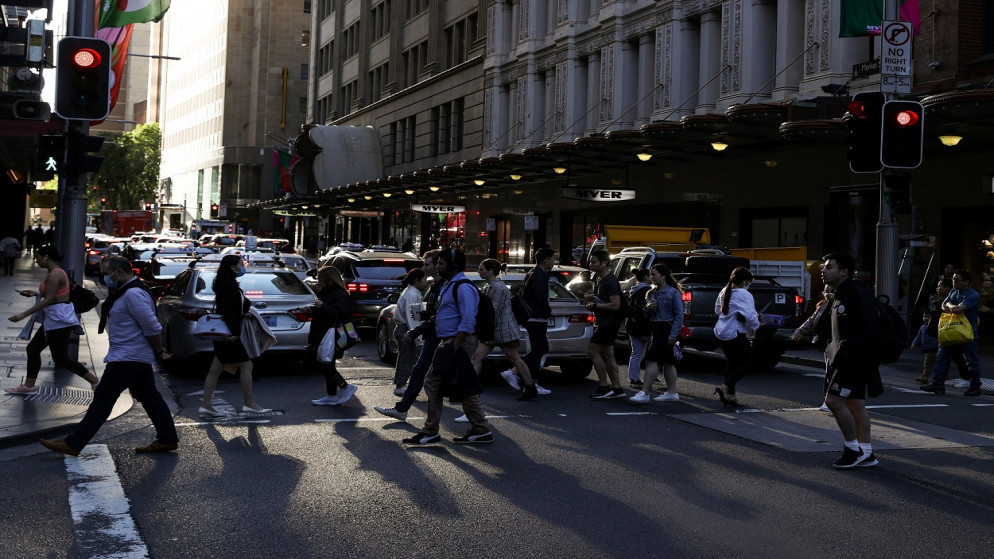 أشخاص يسيرون عبر تقاطع مزدحم في وسط مدينة سيدني، أستراليا، 9 تشرين الثاني/ نوفمبر 2020. (أ ف ب)