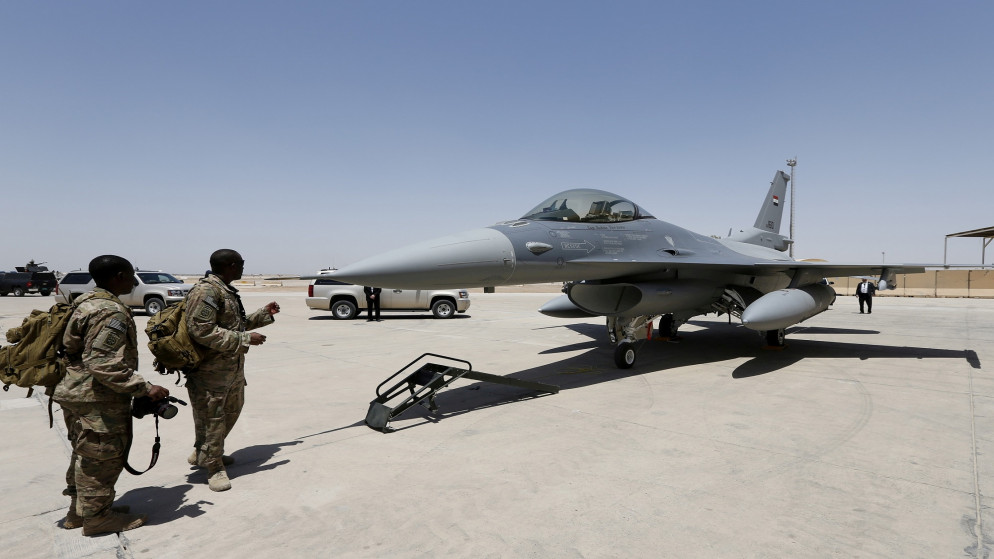 جنود في الجيش الأميركي ينظرون إلى طائرة مقاتلة من طراز إف 16، في قاعدة عسكرية في العراق، 20 يوليو / تموز 2015. (رويترز)