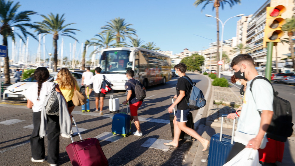 طلاب يغادرون فندقا جرى عزلهم فيه بعد ثبوت إصابتهم بفيروس كورونا في إسبانيا. 01/07/2021. (إنريكي كالفو/ رويترز)