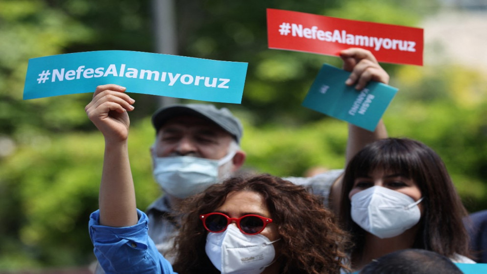 أشخاص يحملون لافتات كتب عليها باللغة التركية "لا نستطيع التنفس" خلال تجمع يطالب بحماية الصحفيين من الشرطة في أنقرة. (أ ف ب)