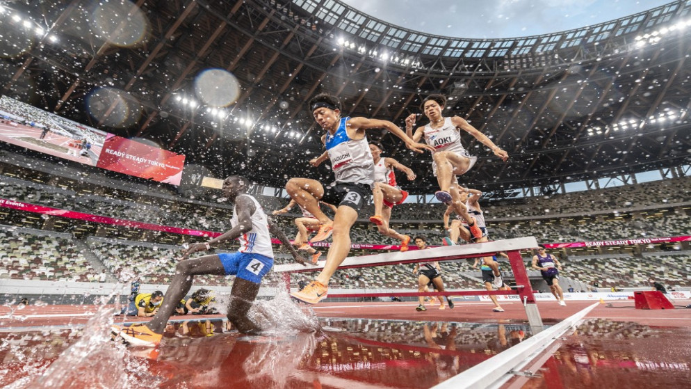 رياضيون في سباق 3000 متر خلال تجربة مضمار داخل الملعب الوطني في طوكيو. 9 أيار/مايو 2021. (أ ف ب)