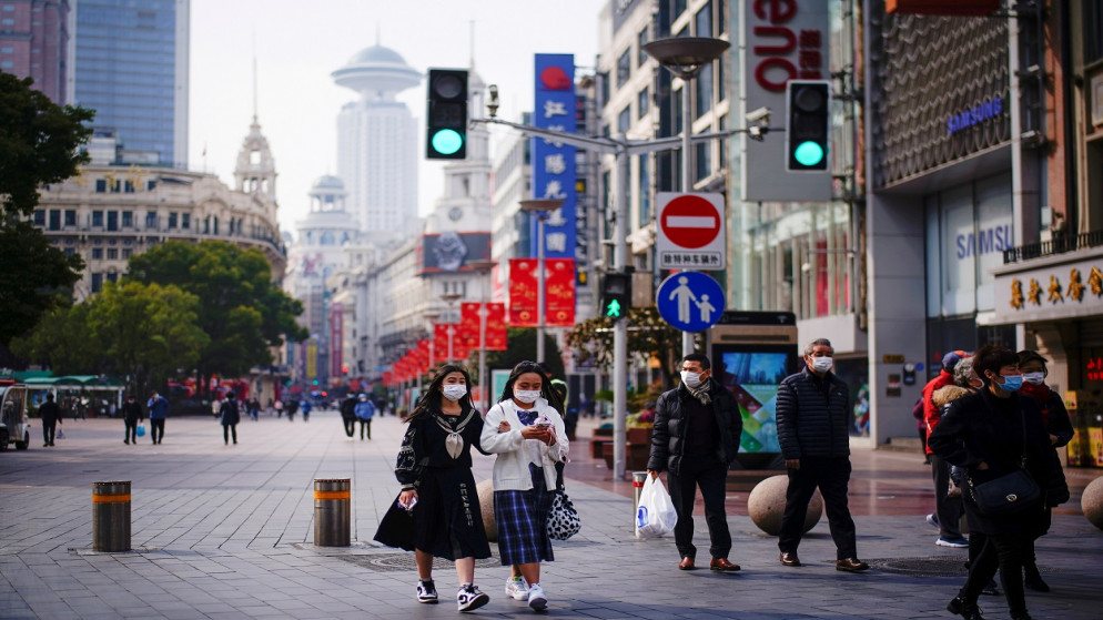 أشخاص يرتدون كمامة للوجه يسيرون في منطقة تسوق رئيسية بعد تفشي فيروس كورونا، في شنغهاي، الصين، 27 كانون الثاني/ يناير 2021. (رويترز)