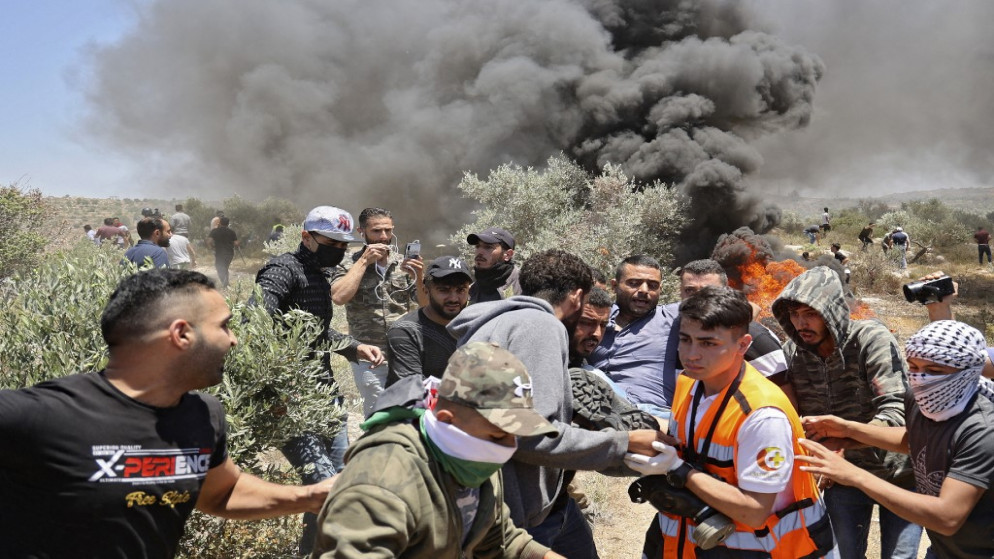 نقل مصاب فلسطيني برصاص قوات الاحتلال الإسرائيلي خلال مواجهات جنوب نابلس. (أ ف ب)