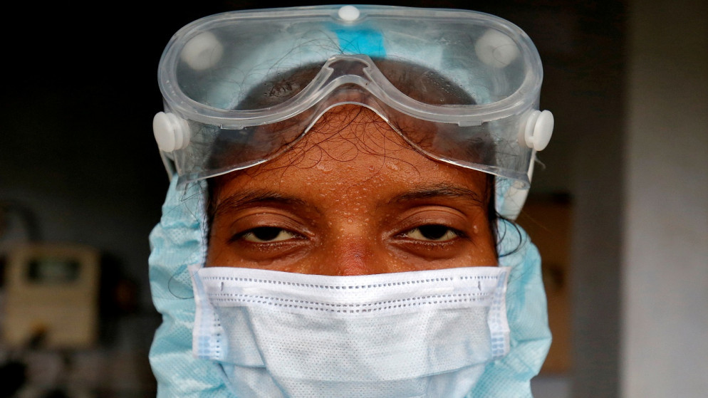 عاملة رعاية صحية ترتدي ملابس واقية بعد أن أخذت مسحات من السكان لاختبار كورونا، في شقة سكنية في أحمد آباد، الهند، (رويترز / أميت ديف)