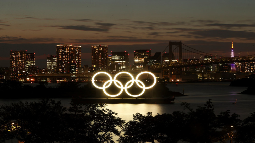 الحلقات الأولمبية المثبتة على منصة عائمة مع جسر قوس قزح استعدادًا لدورة الألعاب الأولمبية طوكيو 2020 في طوكيو، 21 حزيران/يونيو 2021. (رويترز)
