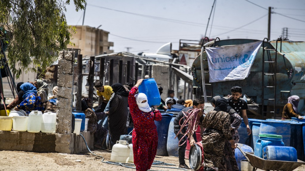 امرأة سورية تحصل على عبوة مياه من "يونيسف" في شمال شرق سوريا. (أ ف ب)