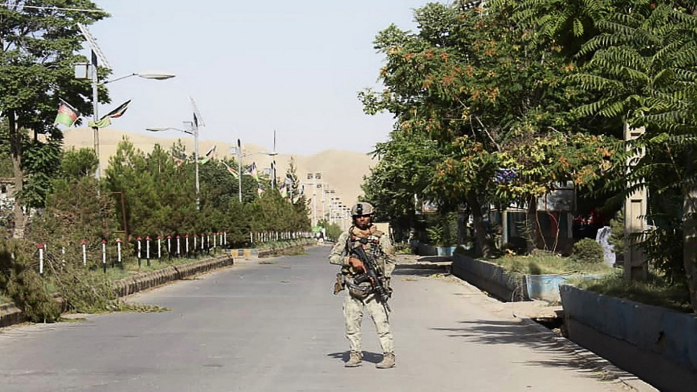 أحد أفراد قوات الأمن الأفغانية يقف على طول طريق وسط قتال دائر مع مقاتلي طالبان في مدينة قلعة ناو الغربية عاصمة إقليم بادغيس. 8/07/2021. (أ ف ب)