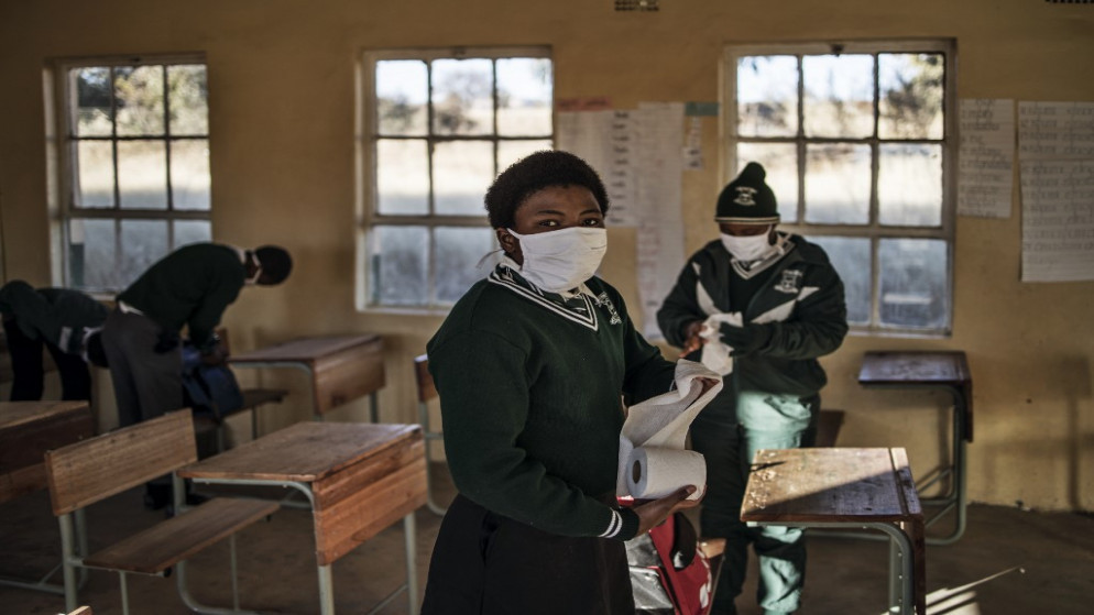 طالبة في الصف السابع في إحدى مدارس ستيركسبرويت في جنوب إفريقيا، تحمل مناديل لتنظيف مكتبها بعد إعادة فتح المدارس في 06 حزيران/ يونيو 2020. (ماركو لونغاري / أ ف ب)