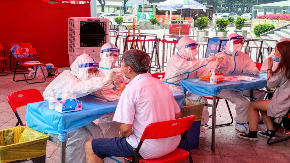 أشخاص يخضعون لاختبارات الحمض النووي لفيروس كورونا في شنتشن بمقاطعة قوانغدونغ جنوب الصين. (أ ف ب)
