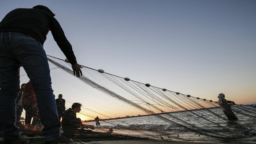 صورة أرشيفية لأشخاص في قطاع غزة يلقون بشبكة صيدهم إلى البحر. (أ ف ب)