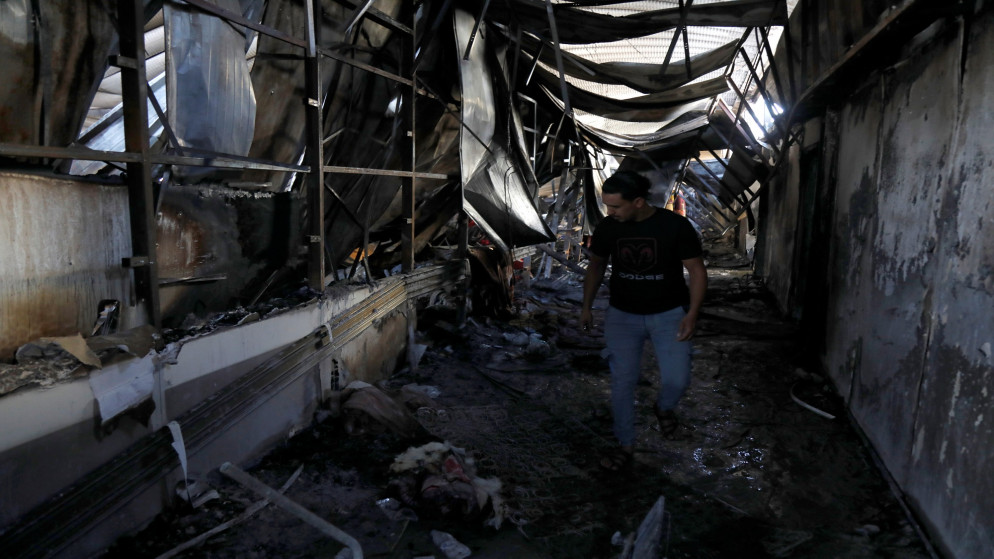 أشخاص يتفقدون الأضرار بعد اندلاع حريق في مستشفى الحسين لعلاج مصابي كورونا في الناصرية بالعراق. 13/07/2021. (عصام السوداني/رويترز)