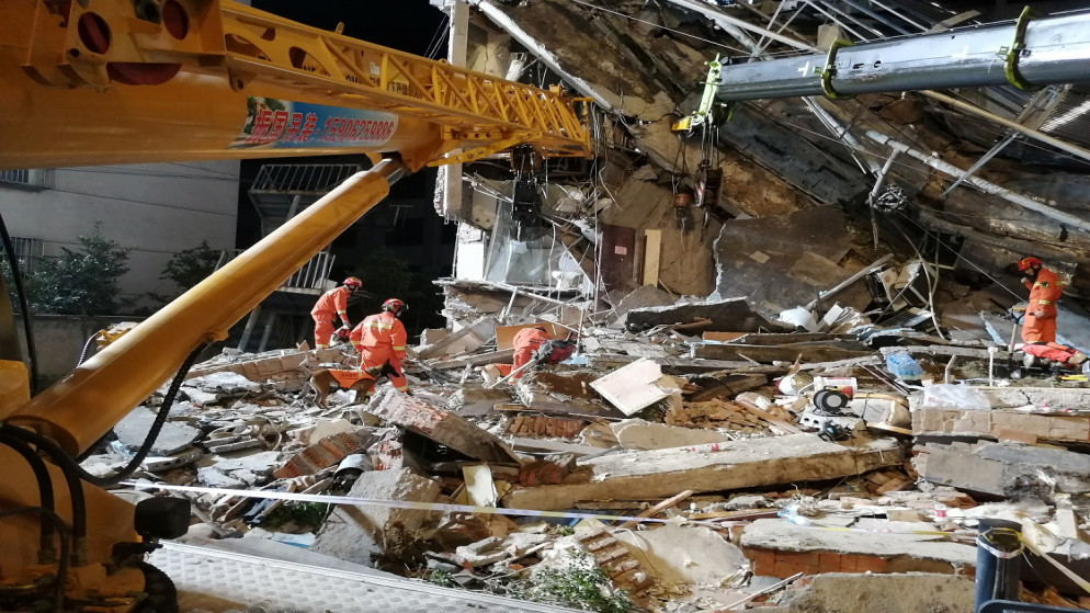 عمال الإنقاذ يعملون في الموقع حيث انهار مبنى فندق في سوتشو، مقاطعة جيانغسو، الصين ، 13 تموز/يوليو 2021. (رويترز)