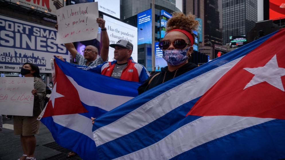 متظاهرون يحملون لافتات خلال مسيرة في نيويورك، تضامنا مع الاحتجاجات المناهضة للحكومة في كوبا. 13/07/2021. (أ ف ب)