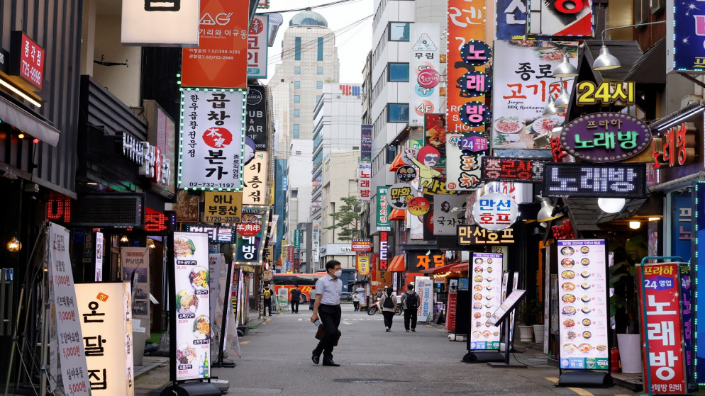 رجل يرتدي كمامة ويسير في شارع شبه فارغ وسط تشديد قواعد التباعد الاجتماعي بسبب جائحة فيروس كورونا في سول، كوريا الجنوبية، 12 تموز/يوليو ، 2021. (رويترز / هيو ران)