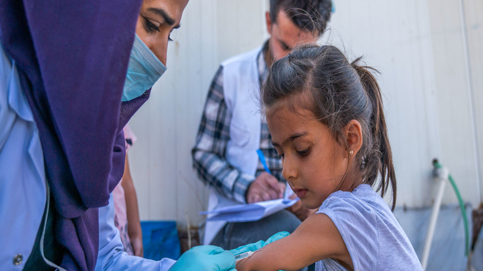 طفلة تحصل على لقاح ضد شلل الأطفال والحصبة في العراق بعد فرارها من الحرب في شمال شرق سوريا. (يونيسف)