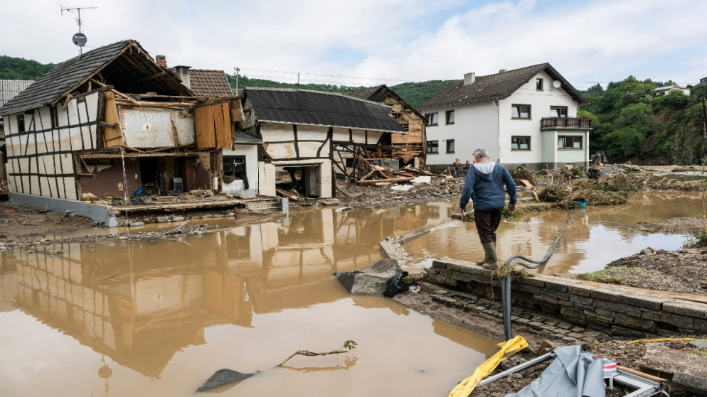 رجل يسير عبر الفيضانات باتجاه المنازل المدمرة في شولد بالقرب من باد نوينار، غرب ألمانيا، 15 تموز/يوليو 2021 (أ ف ب)
