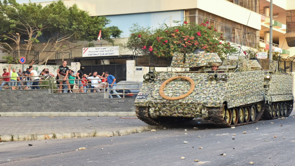متظاهرون يلقون الحجارة على ناقلة جنود لبنانية مدرعة في العاصمة بيروت، 15 يوليو/تموز 2021. (أ ف ب)
