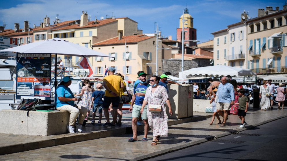 سياح وسكان يمشون في سان تروبيه، جنوب فرنسا في 10 يوليو/تموز 2021. (أ ف ب)