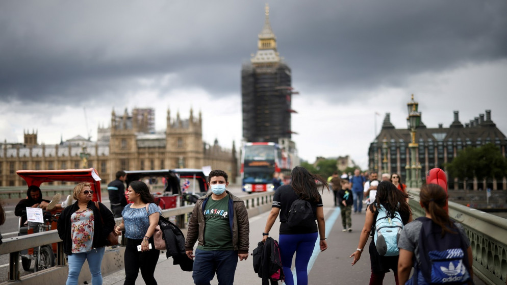 أشخاص يرتدون كمامات، يمشون فوق جسر وستمنستر وسط جائحة فيروس كورونا، لندن، بريطانيا، 4 تموز/ يوليو  2021. (رويترز)