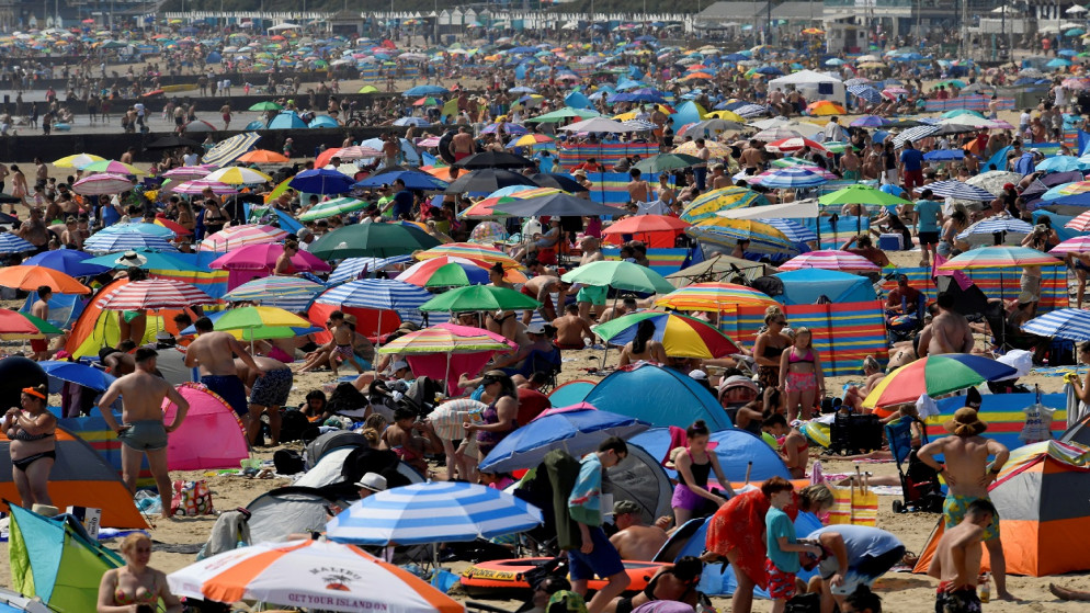 أشخاص يستمتعون بالطقس المشمس على شاطئ بورنماوث، وسط تفشي فيروس كورونا، في بورنموث، بريطانيا، 31 تموز/ يوليو 2020. (رويترز)