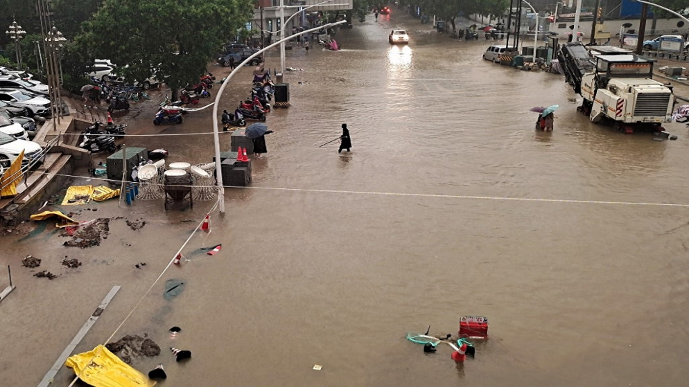 مياه الفيضانات على طول شارع بعد هطول أمطار غزيرة في مدينة تشنغتشو بمقاطعة خنان بوسط الصين، 20 يوليو 2021. (أ ف ب)