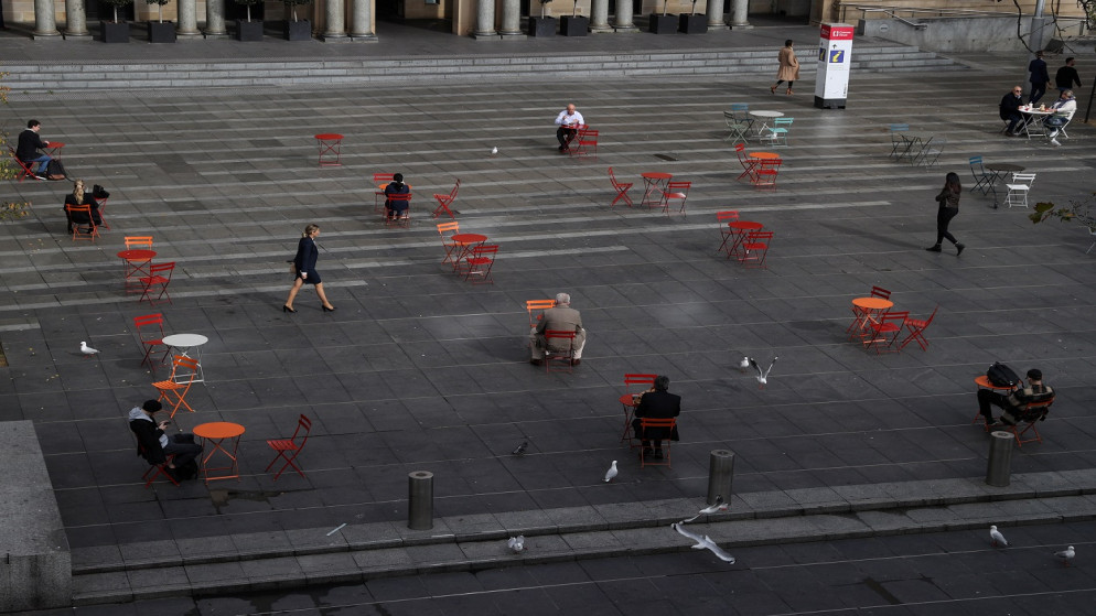 أشخاص يجلسون على طاولات متباعدة جسديا، بينما تشهد ولاية نيو ساوث ويلز تفشي فيروس كورونا، سيدني، أستراليا، 22 يونيو 2021. (رويترز)