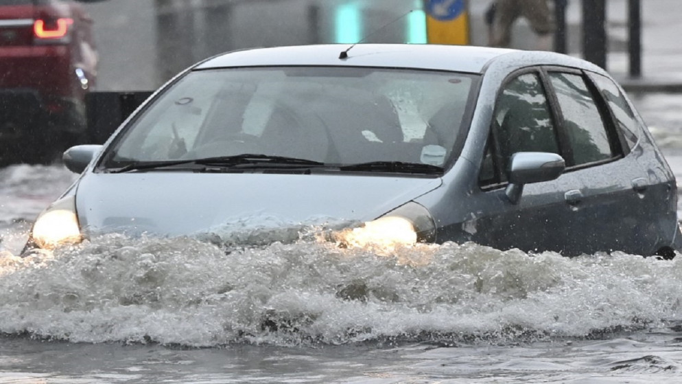 قيادة مركبة عبر المياه العميقة على طريق غمرته المياه في لندن، 25 يوليو 2021. (رويترز)