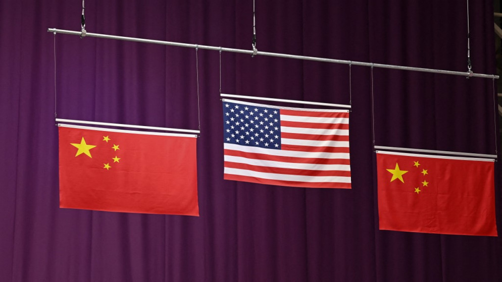 العلمان الأمريكي والصيني خلال حفل الميدالية الفضية للصين. (أ ف ب)