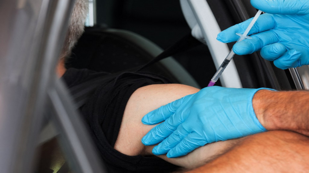 تطعيم رجل في سيارته في مركز للتطعيم في برلين ضد فيروس كورونا 17 تموز/يوليو 2021.(أ ف ب)