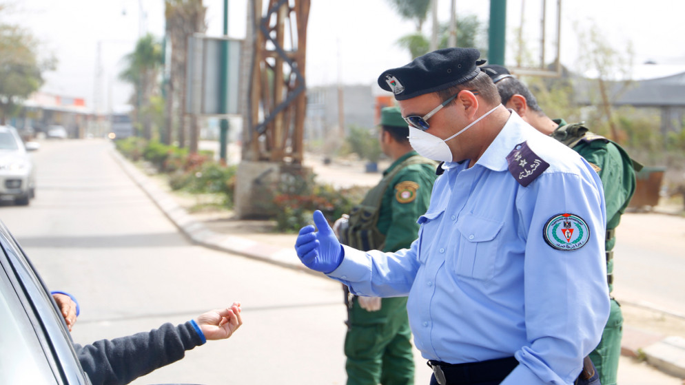 صورة Hرشيفية لشرطي فلسطيني يقف حارسًا عند حاجز على الطريق خلال أزمة كورونا في الأراضي الفلسطنيية.24 آذار / مارس.(shutterstock)