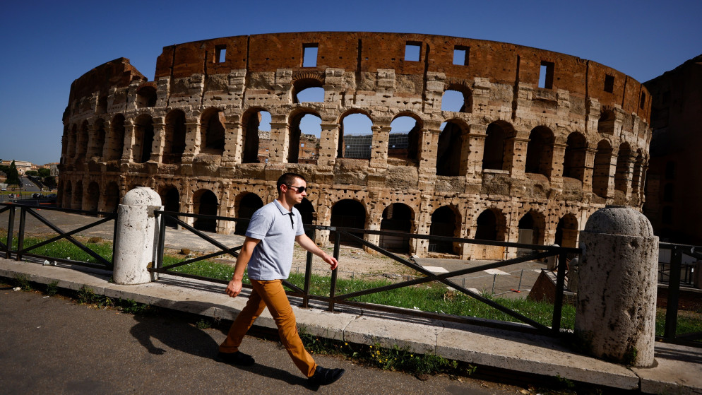 شخص يمشي بدون كمامة في روما بعد إلغاء إلزامية ارتداء الكمامة في الهواء الطلق، 28 حزيران/يونيو 2021. (رويترز)